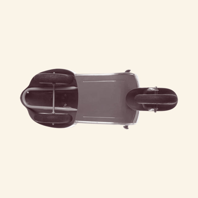Underside view of the AMBOSSTOYS PRIMO ride-on toy scooter showing the wheel placement, metal body construction, and base details.