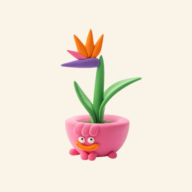 Hey Clay bird of paradise plant character sculpture in a pink flower pot with colorful tropical bloom.