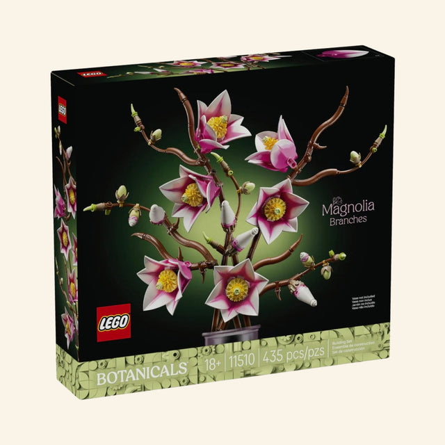 LEGO Botanicals Magnolia Branches 11510 building set in black retail packaging, showing the completed arrangement of pink-and-white magnolia blossoms and twisting brown branches against a dark background.