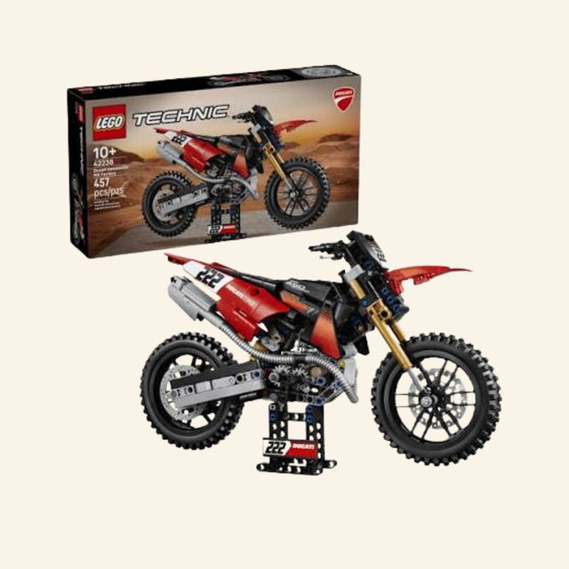 LEGO® Technic Ducati Desmo450 MX Factory set shown with retail box and completed red, black, white, and gold dirt bike model on a display stand, featuring Ducati branding, number 222 graphics, knobby tires, and age 10+ guidance.