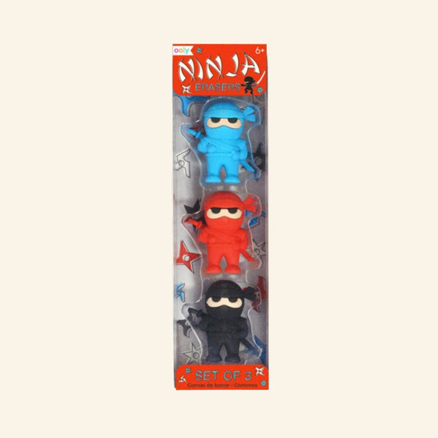 OOLY Ninja Erasers set shown in retail packaging with three ninja-shaped erasers in blue, red, and black, plus colorful ninja-themed package artwork.