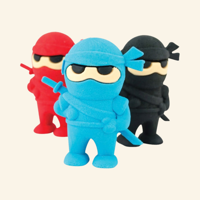 OOLY Ninja Erasers shown out of the package with blue, red, and black ninja-shaped erasers standing together.