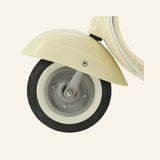 Close-up view of the cream AMBOSSTOYS PRIMO ride-on toy scooter with a brown seat front wheel and fender.