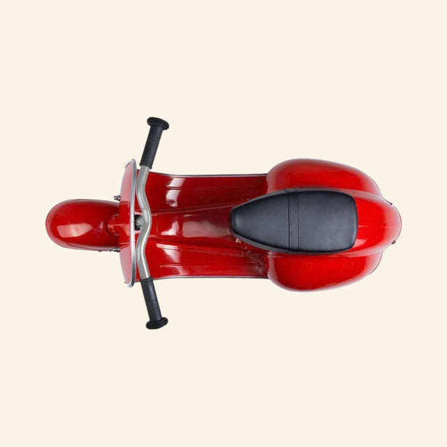 Top view of the AMBOSSTOYS PRIMO ride-on toy scooter in red showing the black seat and handlebar layout.