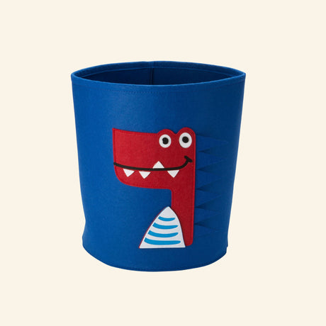 Blue felt storage bin featuring a playful dinosaur face with colorful 3D appliqué details.