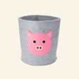 Gray felt storage bin with a layered pink pig face, designed to organize toys, books, blankets, and nursery essentials.