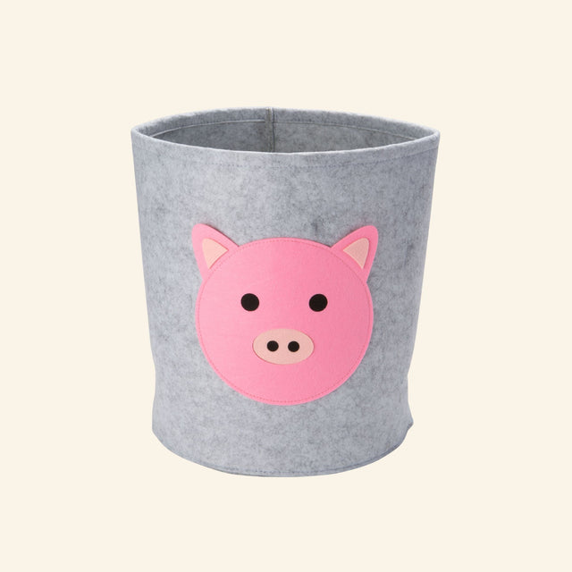 Gray felt storage bin with a layered pink pig face, designed to organize toys, books, blankets, and nursery essentials.