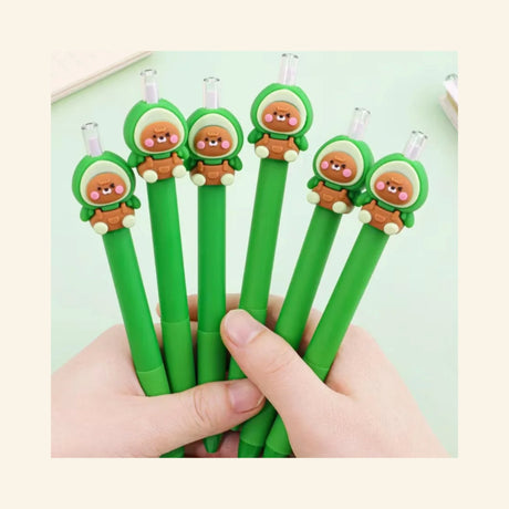 Hand holding several Avocado Bear Retractable Pencils with green barrels and adorable avocado bear toppers, showing the clear retractable pencil tips and matching character designs.