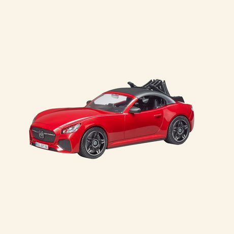 Bruder red roadster shown from the front angle with black wheels, sporty grille, removable roof area, and rear rack attachment.