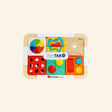 Fat Brain Toys PlayTab Modular Activity Board shown with colorful compatible activity tiles attached, including sensory buttons, a color wheel, gear-style pieces, sliders, and maze-style play features.