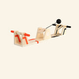 Fat Brain Toys VolleyShot Game shown from the front angle, featuring a wooden tabletop game frame with two red-handled paddles and a black attached ball ready for play.