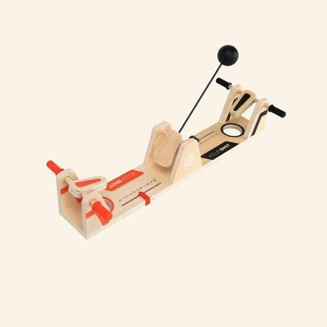 Fat Brain Toys VolleyShot Game shown from a side angle, highlighting the wooden paddle controls, attached ball arm, center scoring area, and compact tabletop design.