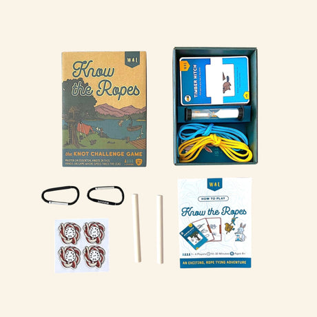 Find New Roots Know the Ropes game contents laid out with the game box, open storage tray, ropes, dowels, carabiner-style clips, knot cards, stickers, and illustrated instruction booklet.