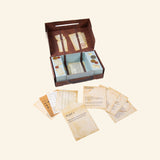 Fizz Creations Solve the Case shown open with mystery cards, puzzle sheets, envelopes, and case contents arranged around the suitcase-style game box.
