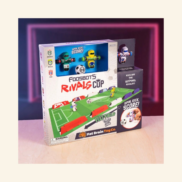 Foosbots Rivals Cup tabletop soccer game featuring three international Foosbots, a felt soccer field, barriers, mini soccer balls, and built-in score sliders.