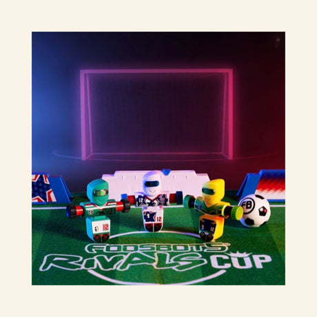 Three Foosbots from the USA, Brazil, and Mexico competing on the Foosbots Rivals Cup soccer field with mini soccer balls and stadium barriers.