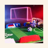 Player squeezing a Foosbot's arms to spin and kick a mini soccer ball during a fast-paced Foosbots Rivals Cup match.