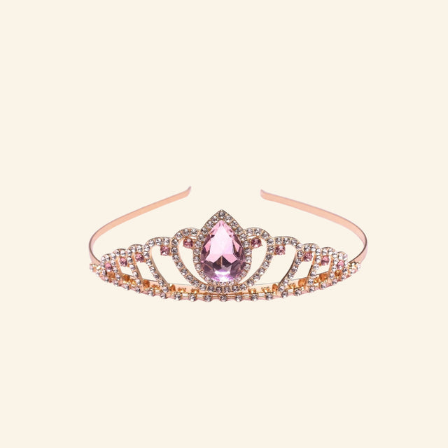 Great Pretenders Boutique Regal Tiara shown in rose gold with sparkling rhinestones, curved crown detailing, and a large pink teardrop gemstone centerpiece.