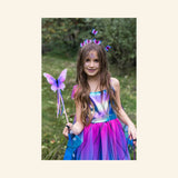 Child wearing a colorful butterfly-inspired dress and holding the Great Pretenders Float Like a Butterfly Wand outdoors.