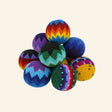Assorted handmade Guatemalan foot bags stacked together, showing colorful crocheted patterns in blue, green, yellow, purple, red, orange, and black.