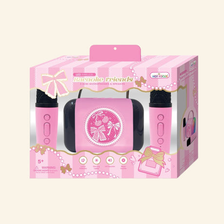 Hot Focus Wireless Karaoke Friends – Bowtiful retail box showing a pink LED speaker with bow and cherry artwork, two pink mini microphones, bow-themed packaging, and icons for lyrics eliminator, dancing lights, HiFi speaker, and magic sounds.