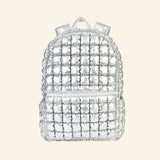 iScream Icy Silver Puffer Backpack shown from the front, featuring shiny metallic silver quilted nylon, a rounded top, front zippered pocket, top handle, and padded shoulder straps.