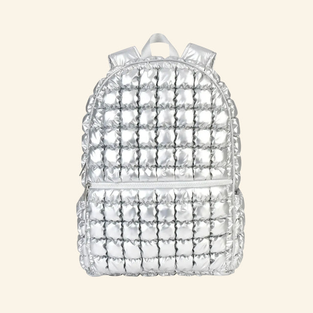 iScream Icy Silver Puffer Backpack shown from the front, featuring shiny metallic silver quilted nylon, a rounded top, front zippered pocket, top handle, and padded shoulder straps.