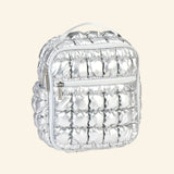 iScream Icy Silver Puffer Lunch Tote shown from an angled side view, highlighting the metallic quilted puffer texture, front zipper pocket, side pocket, top handle, and rounded zipper top.
