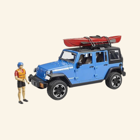Blue Bruder Jeep Wrangler Rubicon Unlimited with red kayak secured to the roof rack and kayaker figure standing beside the vehicle.