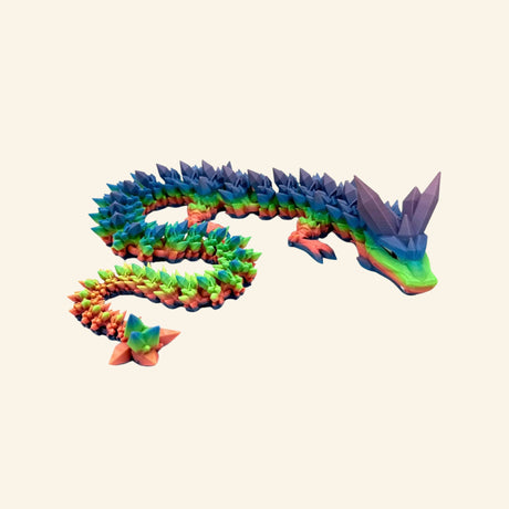 Jumbo crystal dragon stretched into a curved pose, showing its long articulated body, pointed blue and purple back scales, multicolored legs, green head, and flexible tail.