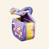 LEGO® Creator Create Art Fashion Bag shown open to reveal the storage compartment, with pastel decorative tiles, purple interior, hinged lid, and small keychain charm pieces.