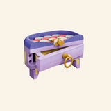 LEGO® Creator Create Art Fashion Bag shown as a small storage box with lid open, lavender and yellow sides, gold-style bow detail, and pastel round tiles visible inside.