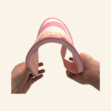 The Liontouch Queen Rosa Shield being gently bent by hand to show the lightweight, flexible EVA foam construction.