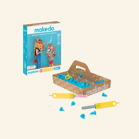 Makedo Explore Tool Set shown with retail box, cardboard storage tray, yellow Scru-Driver, Safe-Saw, blue connectors, Scrus, and small cardboard pieces for construction play.
