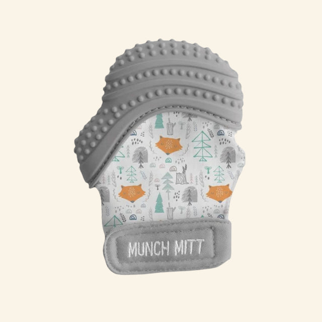 Malarkey Kids Munch Mitt shown in gray with a woodland animal print fabric mitten, textured gray silicone teething top, adjustable wrist strap, and soft mitten shape.