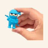 Blue OOLY Ninja Eraser held between fingers, showing the small 1 ¾ inch ninja character shape and sword detail.