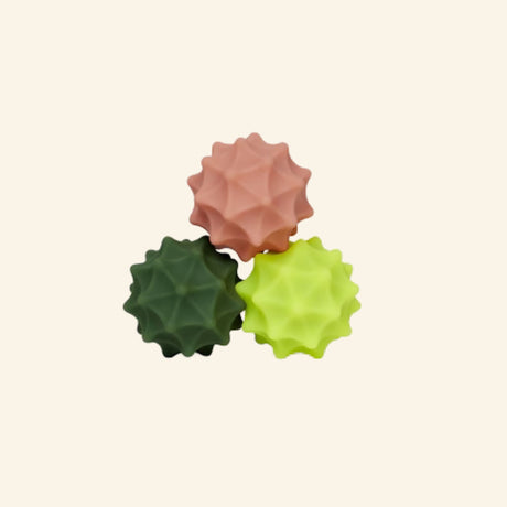 Three Speks Odds Spurs magnetic fidgets grouped together in peach, dark green, and bright yellow-green, each with a raised geometric spiked texture.