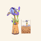 Robotime Rowood Purple Iris DIY Wooden Flower 3D Puzzle shown completed in a small illustrated paper-style vase beside the matching project card and packaging artwork.