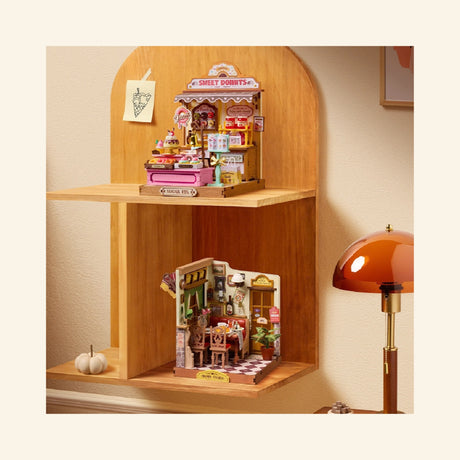 Rolife Sweetie’s Donut Shop miniature displayed on a wooden shelf with other miniature shop builds, showing its compact size and decorative display style.