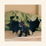 Schleich® ELDRADOR® Creatures Shadow Dragon shown in a bedroom play scene with wings spread in front of green bedding.