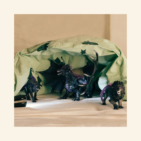 Schleich® ELDRADOR® Creatures Shadow Dragon shown with other fantasy creature figures during an imaginative play scene on a bed.