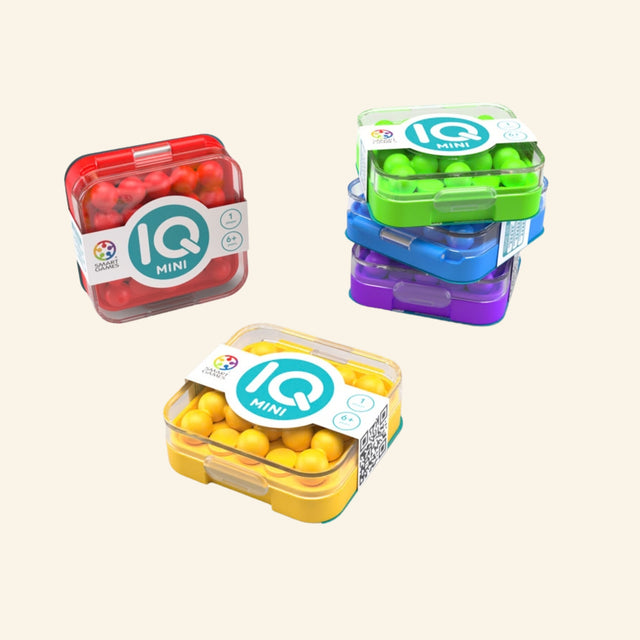 SmartGames IQ Mini assortment shown in red, green, yellow, and purple compact travel cases, highlighting the assorted color options.