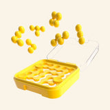 SmartGames IQ Mini yellow puzzle case shown with yellow puzzle pieces floating above the open board, demonstrating the pieces used to complete the challenge.