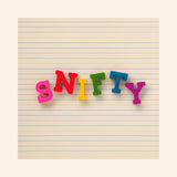 Snifty ABC Crayons arranged on lined paper to spell “SNIFTY” using bright red, pink, yellow, green, blue, and teal letter-shaped crayons.