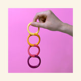 Hand holding the SPEKS 8 Helix Purple Plasma magnetic fidget coil vertically to demonstrate its flexible magnetic design.