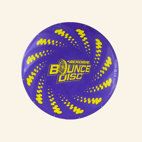 Spin Master Aerobie Bounce Disc shown unboxed from above, featuring a purple flying disc with bright yellow swirl graphics and the Aerobie Bounce Disc logo in the center.