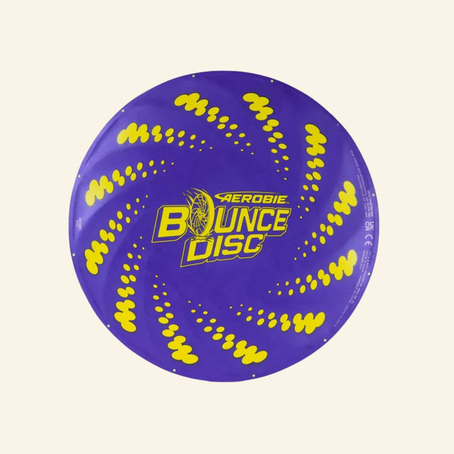 Spin Master Aerobie Bounce Disc shown unboxed from above, featuring a purple flying disc with bright yellow swirl graphics and the Aerobie Bounce Disc logo in the center.