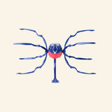 Spin Master HEX BOTS Skitter Bot Spider shown from the front in a blue and red colorway, highlighting the spider-like body, long legs, and pointed rear detail.