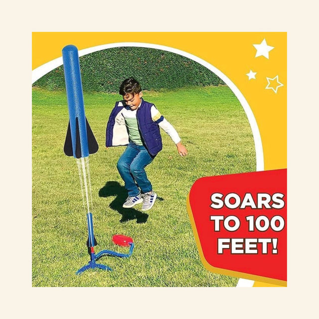 Child stomping the launch pad of a Stomp Rocket Jr. outdoors as a blue foam rocket launches from the stand, demonstrating how the rocket can soar up to 100 feet.
