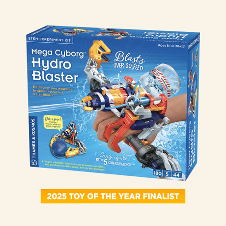 Thames & Kosmos Mega Cyborg Hydro Blaster retail box showing the buildable orange, blue, and gray wearable water blaster with claw, water stream graphics, 180-piece count, and 2025 Toy of the Year finalist badge.
